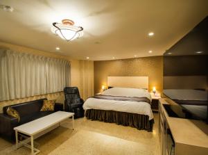 a hotel room with a bed and a chair and a couch at Hotel Flower Style koriyama tenri in Tenri