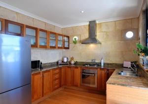 a kitchen with wooden cabinets and a stainless steel refrigerator at Radford Retreat in Safety Bay