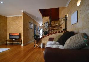 a living room with a couch and a staircase at Radford Retreat in Safety Bay +2 photos