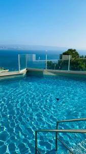 a swimming pool with a view of the ocean at Eluchans One with Pool & parking near Reñaca Beach in Viña del Mar