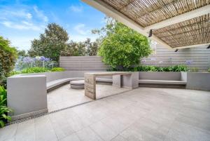 a patio with a bench and a table at Eluchans One with Pool & parking near Reñaca Beach in Viña del Mar