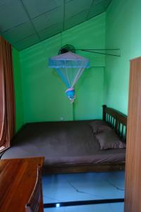 a green bedroom with a bed with a ceiling at MENAKA HOMESTAY in Tangalle
