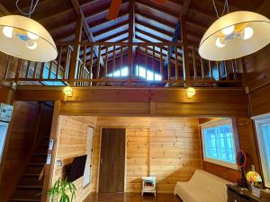 a room with wooden walls and wooden ceiling with two lights at beau lac biwako annex in Takashima