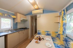 a kitchen with a table and chairs in a room at Camping Villaggio Il Pilone in Rosa Marina