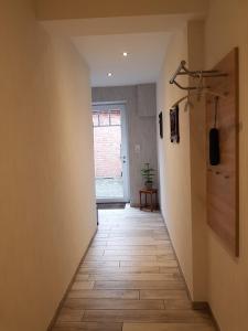 a hallway with a wooden floor and a window at Omas Stübchen - Monteurwohnung auf dem Land in Borken
