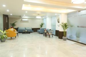 a waiting room with couches and tables and plants at CORPORATE STAYS-Golf Course Road in Gurgaon