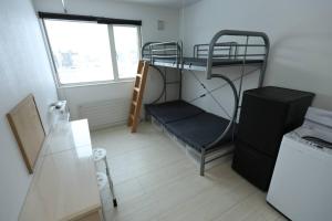 a small room with a bunk bed and a window at バーニングハーツ in Asahikawa