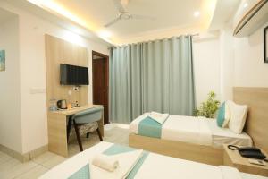 a hotel room with two beds and a desk at CORPORATE STAYS-Golf Course Road in Gurgaon