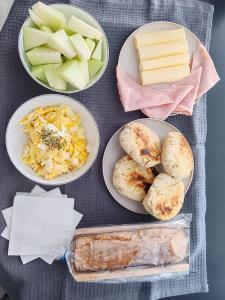 a table topped with plates of food with bread and cheese at Riviera Mendoza in Las Compuertas
