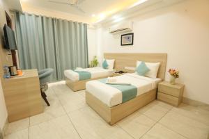 a hotel room with two beds and a television at CORPORATE STAYS-Golf Course Road in Gurgaon +31 photos