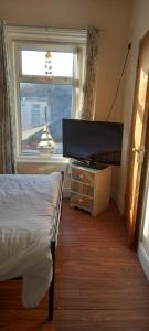 a bedroom with a bed and a flat screen tv at The Osprey Hotel in Blackpool