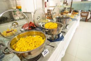 a buffet line with buckets of food on a counter at Brisa do Mar Praia Hotel in Morro de São Paulo