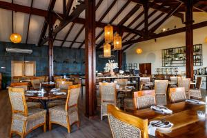 a dining room with wooden tables and chairs at The Kelway Hotel in Port Elizabeth