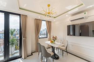 a dining room with a table and chairs and a window at Bailey Hotel Hue in Hue