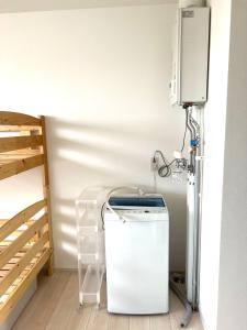 a room with a refrigerator and a tv on a wall at バーニングハーツ in Asahikawa