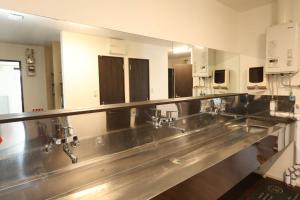 a kitchen with a row of sinks and mirrors at バーニングハーツ in Asahikawa