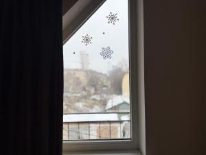 a window with snowflake snowflakes on the window at Odessa Guest House-City Center in Chişinău +51 photos