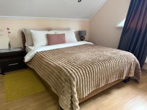 a bedroom with a large bed with a brown blanket at Odessa Guest House-City Center in Chişinău
