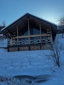 a log cabin with snow in front of it at Zrub House in Slavske