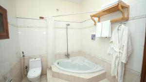 a bathroom with a toilet and a bath tub at World Inn by WIH in Karachi