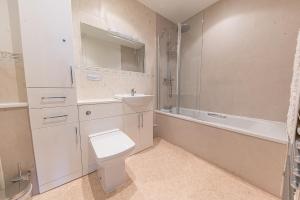 a bathroom with a toilet and a sink and a tub at 16 Greta Grove House in Keswick +19 photos