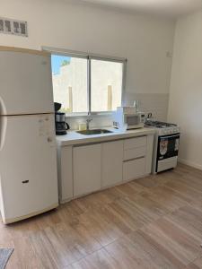 a kitchen with a white refrigerator and a sink at Ms3M casa in San Pedro
