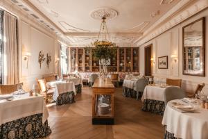 a dining room with tables and chairs and a chandelier at Hotel Único Madrid, Small Luxury Hotels in Madrid