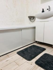 a bathroom with a sink and a black rug at Книжка in Vinnytsya