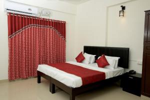 a bedroom with a bed with a red curtain at Hotel O Technopark Formerly Le Frank in Trivandrum