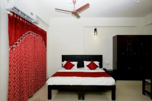 a bedroom with a bed with red pillows on it at Hotel O Technopark Formerly Le Frank in Trivandrum