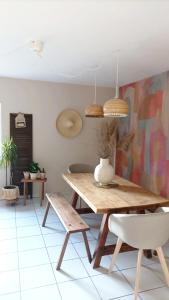 a dining room with a wooden table and chairs at Gîte Minimalist indépendant au calme in Commentry