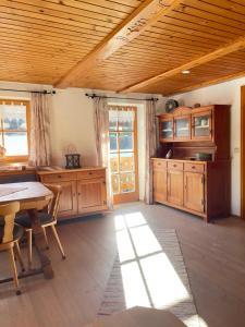 a large kitchen with wooden cabinets and a table at Apartment Rothenlehen in Bischofswiesen