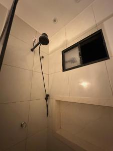 a bathroom with a shower with a tv on the wall at Flat Dourado a 5minutos do Parnaíba Shopping in Parnaíba +11 photos