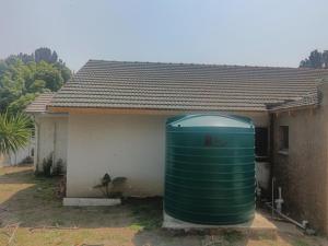 a green water tank sitting outside of a house at 12 Bologna B&B in Evander