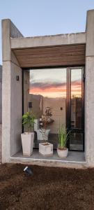 a building with three potted plants in a window at Riviera Mendoza in Las Compuertas
