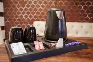 a black coffee maker on a tray on a table at Hotel Leaf Inn in Lucknow