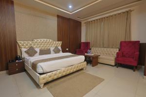 a bedroom with a bed and a couch and a chair at Hotel Leaf Inn in Lucknow +74 photos