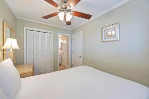 a bedroom with a white bed and a ceiling fan at SC217A: 217A Sea Cabin in Isle of Palms +26 photos