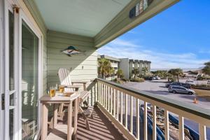 a balcony with a table and chairs and a view of a street at SC217A: 217A Sea Cabin in Isle of Palms