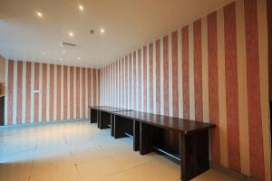 a room with red and white striped walls and desks at Hotel Leaf Inn in Lucknow