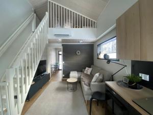 a living room with a couch and a staircase at Villa Anilia in Syöte