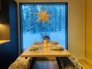a dining room table with a large star on the window at Villa Anilia in Syöte