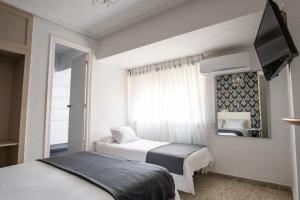 a bedroom with two beds and a mirror at Hostal On Dormire Valencia in Valencia