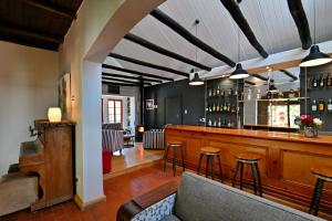 a bar with a couch and chairs in a room at Mimosa Lodge in Montagu