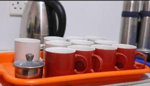 a tray filled with red coffee cups on a counter at JD LUXURY HOTEL Jinja in Jinja