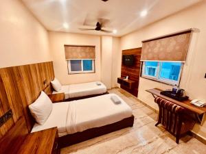 a hotel room with two beds and a desk at Hotel Windsor Plaza in Hyderabad +22 photos