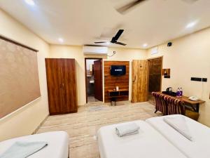 a living room with a bed and a desk and a room at Hotel Windsor Plaza in Hyderabad