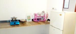 a kitchen with a counter with a white refrigerator at Yasiru Villa in Weligama