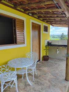a patio with a table and chairs and a tv at Chalésforquilha in Delfinópolis