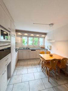 a kitchen with a wooden table and chairs in it at Garden Park Apartment in Interlaken
